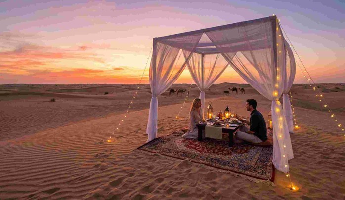 A couple enjoying a romantic meal with a personal chef and soft lighting in the desert, showcasing the magical atmosphere of a Sunset Dune Dinner Abu Dhabi Private Experience.